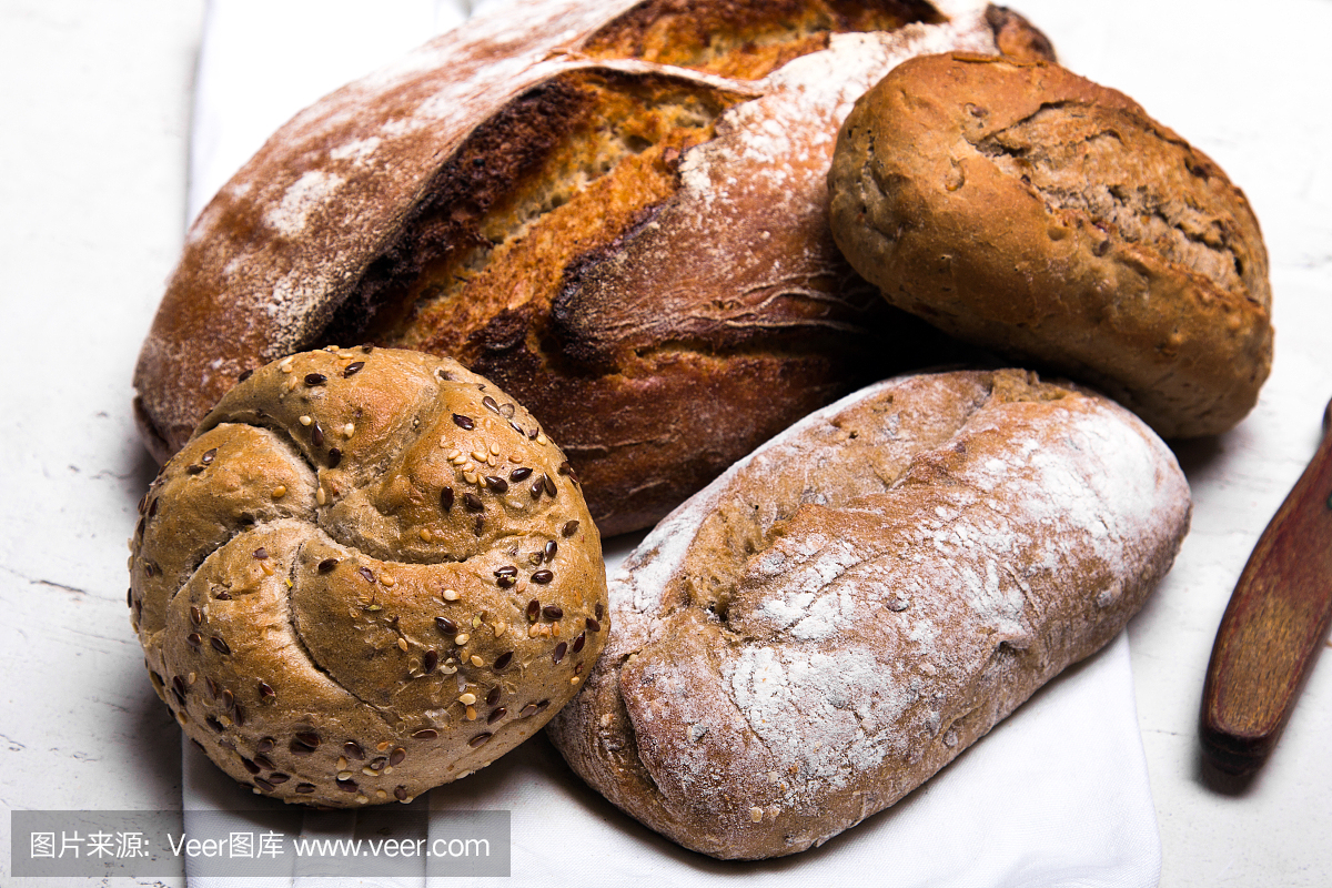 美味的黑面包和小圆面包在白色的背景,拷贝空间。烘焙产品,全麦面包和棕色全麦面包